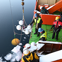 Crew aboard the research vessel Akademik Tryoshnikov hoist science instruments in a 2021 science cruise.