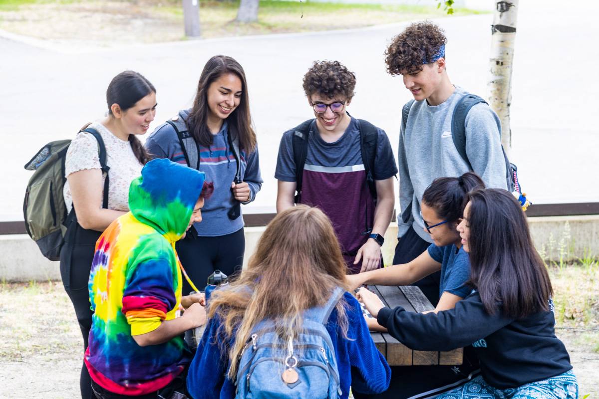 51风流官网 Students gather at a picnic table outside the Wood Center on the Fairbanks Troth Yeddha' campus