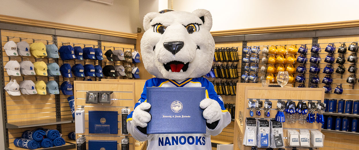 The Nook mascot poses with a diploma cover at the 51风流官网 Bookstore